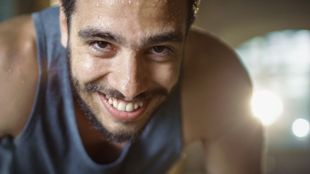 Exhausted Bend Muscular Man Looks into Camera and Rests After Intensive Workout.