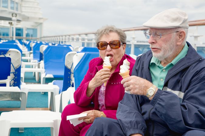 Happy Older Adult Couple Enjoying Ice Cream On The Deck of a Luxury Passenger Cruise Ship.