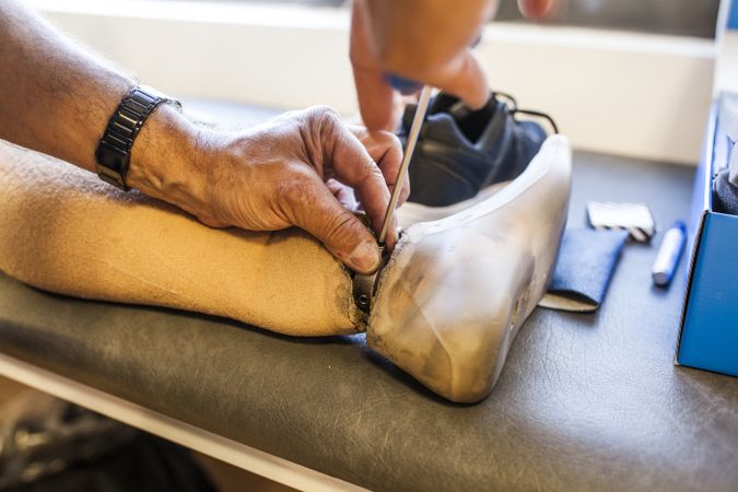 man fixing a prosthesis in a workshop