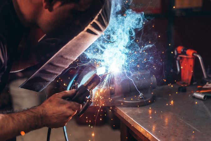 Professional welder in mask welding metal