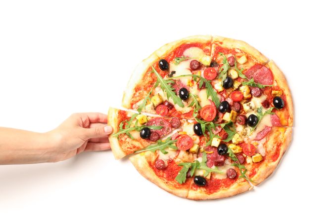Female hand takes a piece of pizza, isolated on plain background