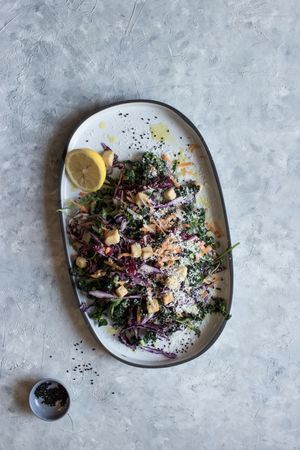 Poppy seeds and lemon near vegetable salad with croutons and parmesan