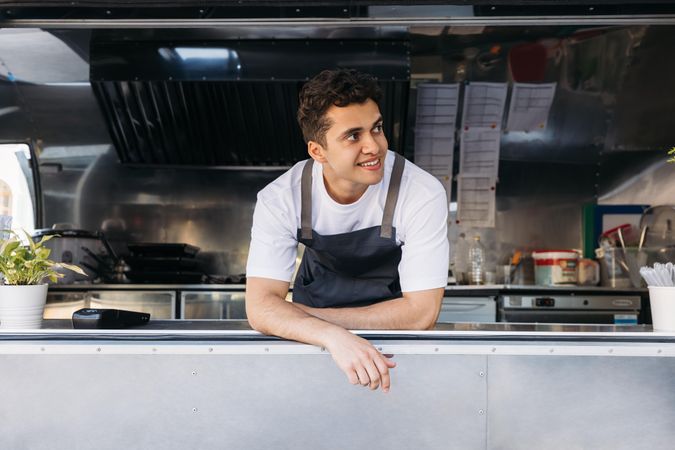 Smiling food truck cook in open kitchen