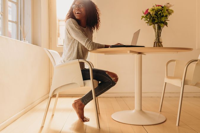 Woman entrepreneur managing her business from home working on laptop computer