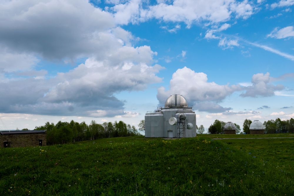 Multiple observatory domes on grassy hill