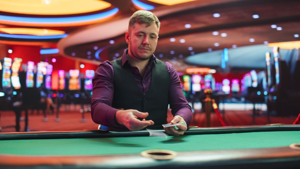 Male Poker Dealer Is Dealing Playing Cards In Luxurious Casino.