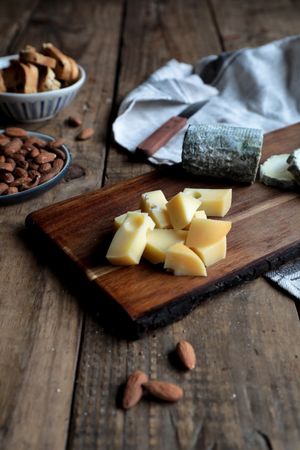 Croutons and nuts near board with cheese
