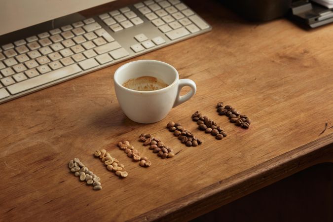 Different grades of coffee beans with coffee cup and computer