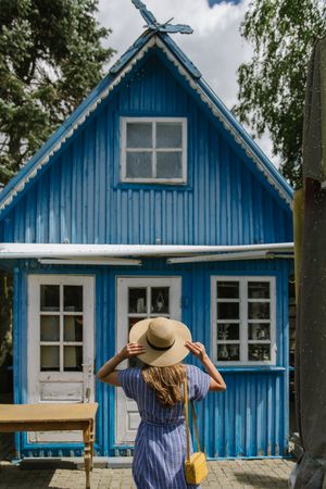 Young woman standing in front of country house