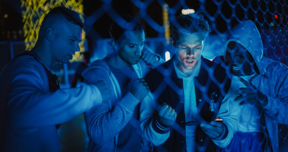 Group of Young Diverse Men Watching a Sports Game on Smartphone Device, Cheering for Their Favorite Team