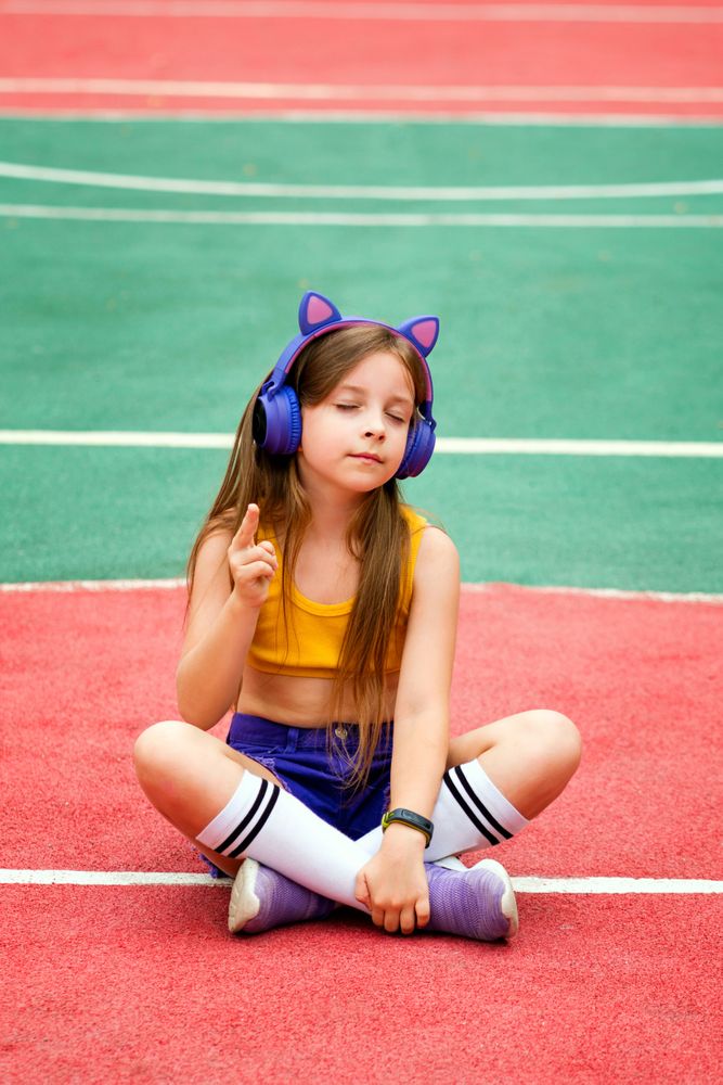 Schoolgirl preteen resting on sports ground