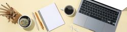 Top view banner of laptop, notebook, pens, coffee, cactus, earbuds with copy space