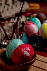 Set of painted Easter eggs in container on table