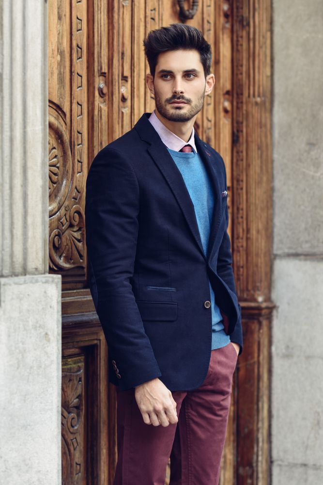 Attractive man in the street wearing elegant suit in front of ornate door