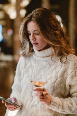 Stylish woman drinking wine in bar