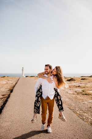 Happy lovers having fun on path from sea