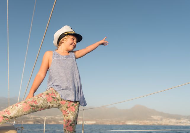 Smiling girl sitting on deck of yacht in sea