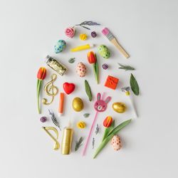 Easter egg shape made of various Easter decorations and leaves