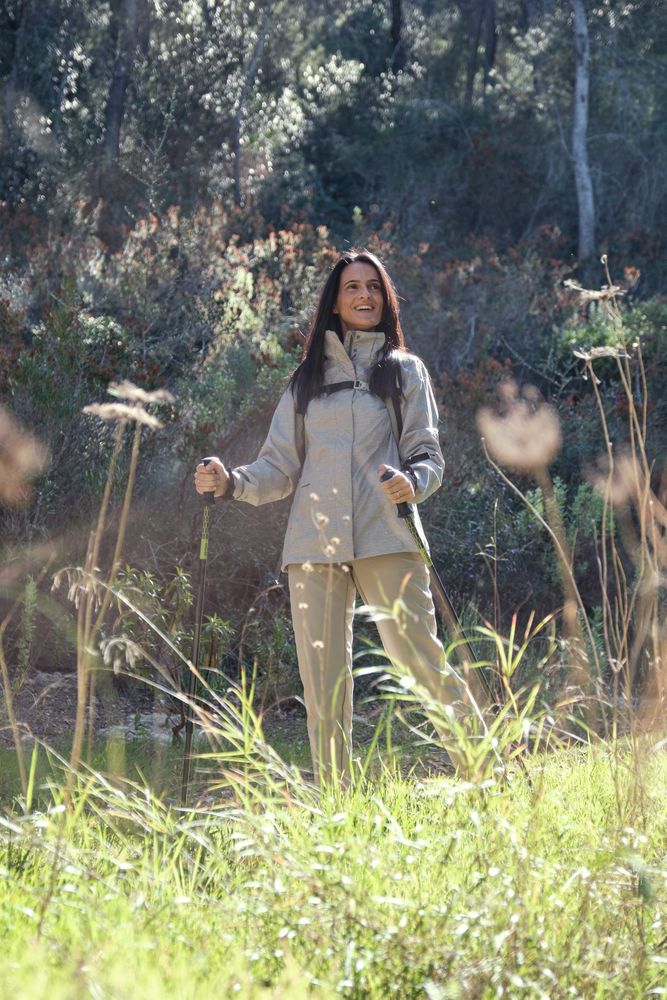 Hispanic woman with walking poles in nature