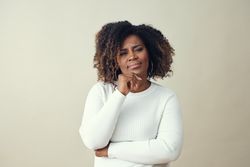 Portrait of curious Black woman with her hand to her chin