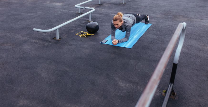 Fitness woman doing push-ups at outdoor gym