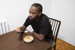 Quiet Morning Routine: Man Eating Cereal in Minimalist Home Setting