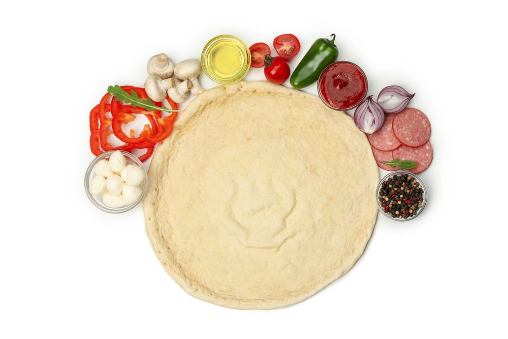 Dough and ingredients for cooking pizza isolated on blank background