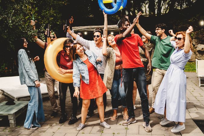 Happy diverse people dancing carefree at spring break party outdoor, having fun together poolside