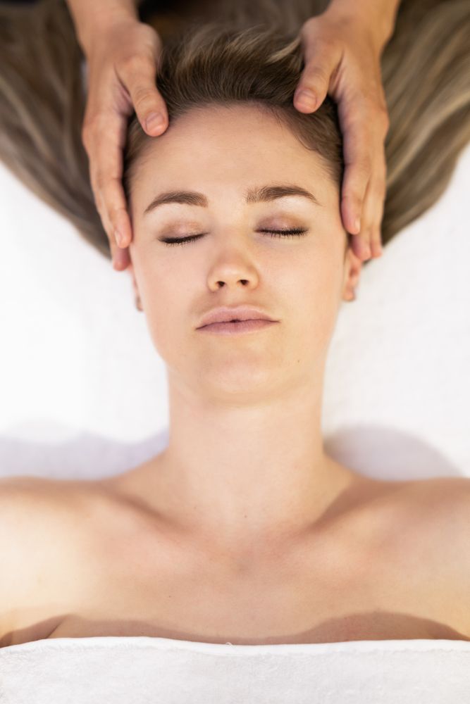 Young woman receiving a head massage in a spa center