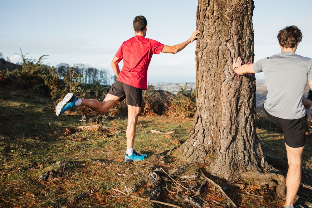 Active men warming up before running in mountains