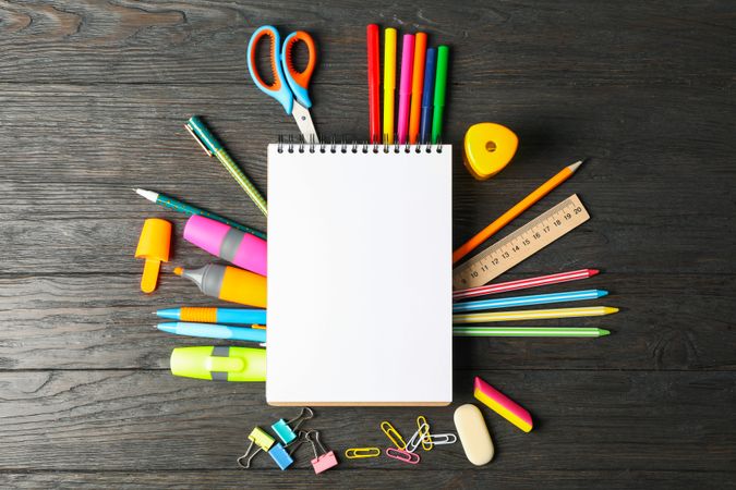 Flat lay composition with school supplies on wooden background, space for text
