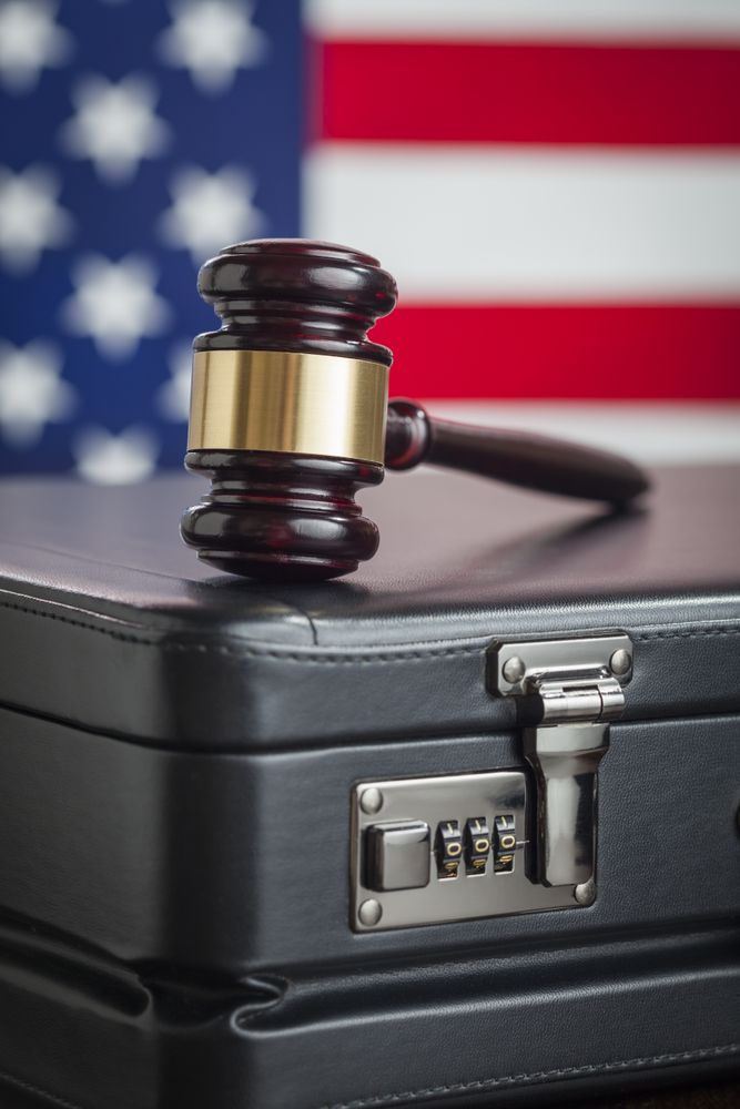 Briefcase and Gavel Resting on Table with American Flag Behind