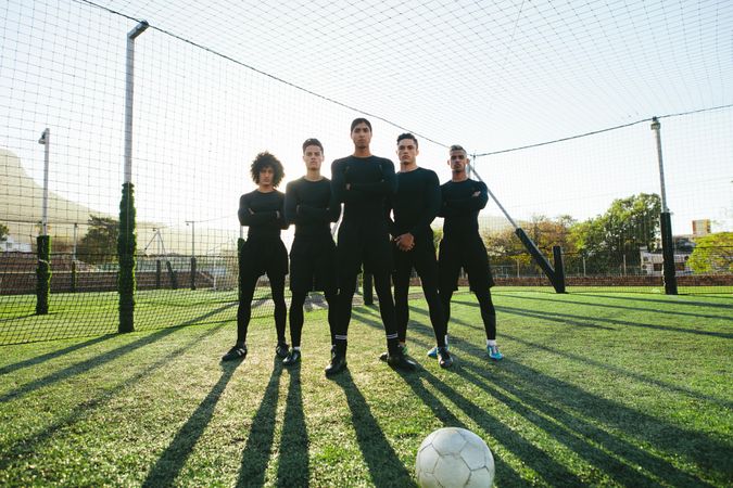 Full length of five-a-side soccer team on field during training