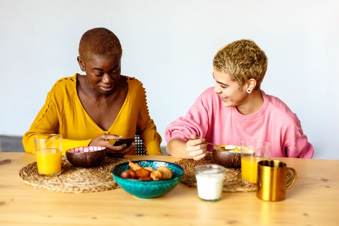 Two multi-ethnic females having breakfast together at home