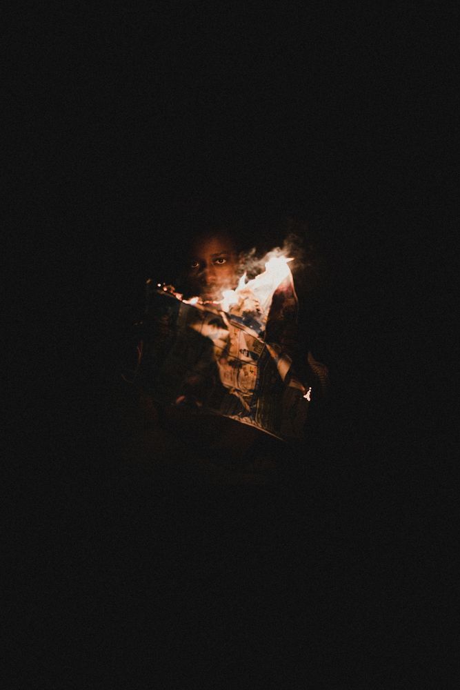 Person holding an illuminated object in a dark room