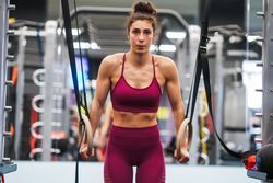Fit woman on gymnastic hoops at gym