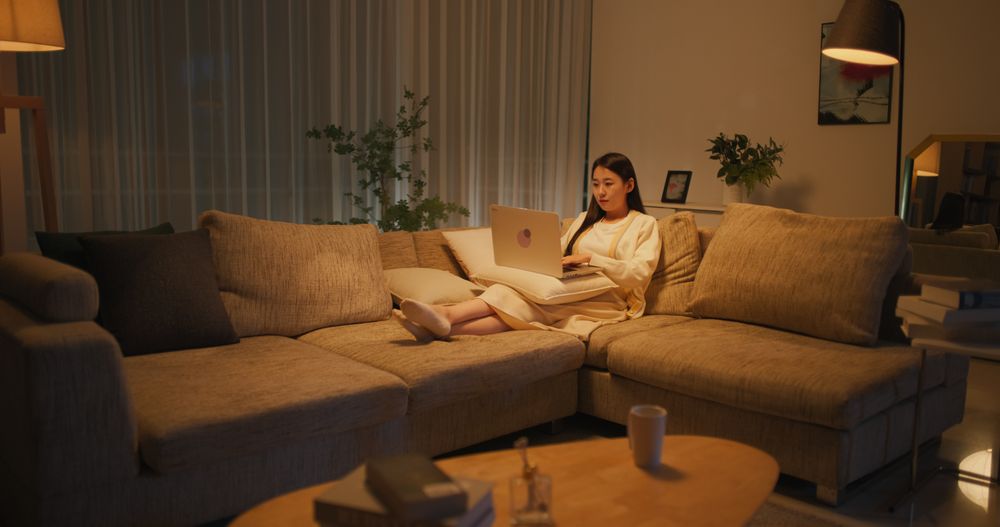 Asian Female Browsing Internet, Using Laptop Computer at Home in the Evening