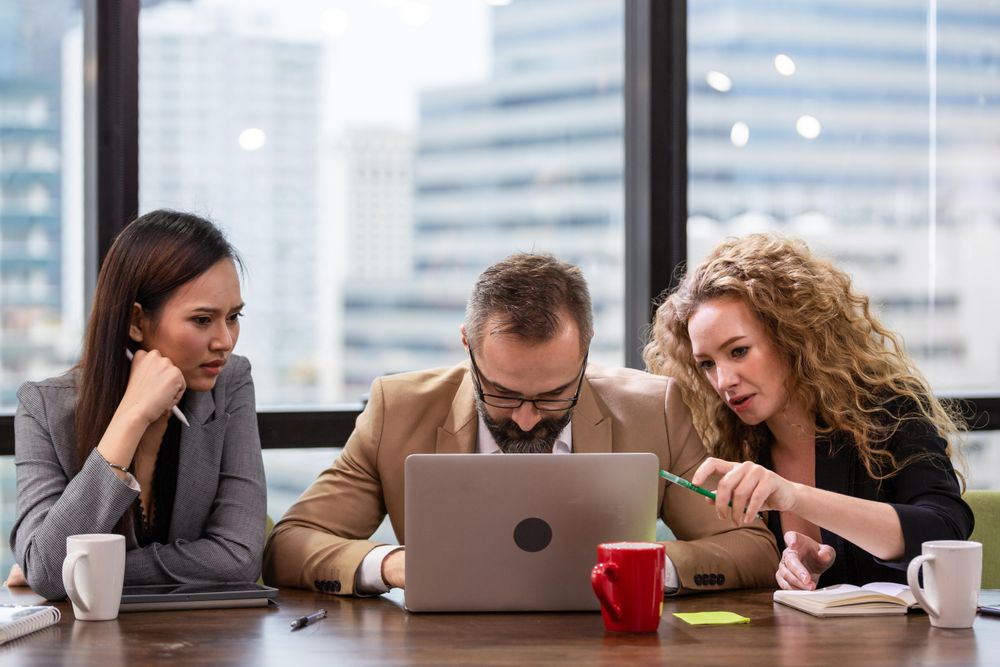 Group of businesspeople concentrating on their work on laptop screen