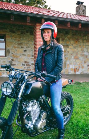Woman with helmet riding custom motorbike