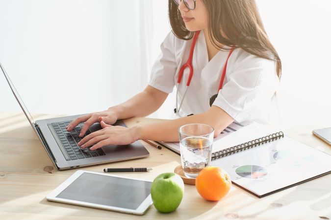Doctor typing on laptop in hospital