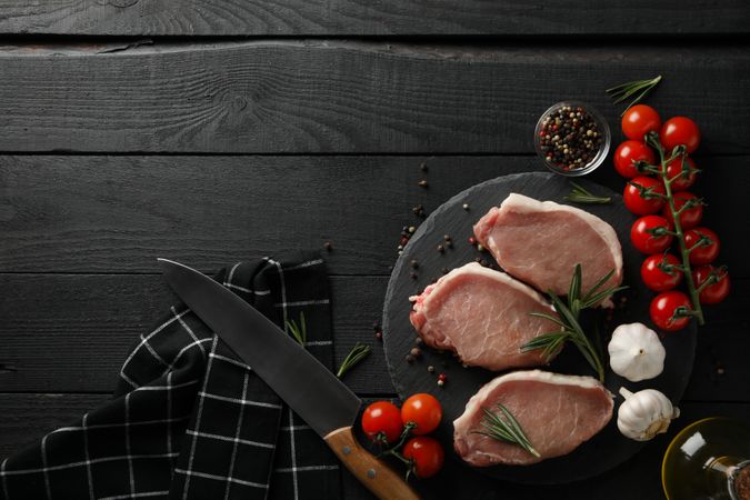 Composition with raw meat for steak and ingredients on wooden background