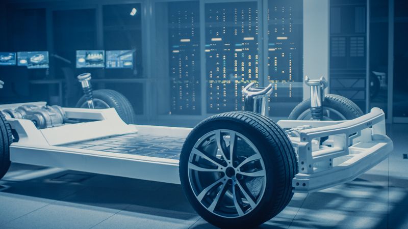 Automobile Engineers Discussing and Designing Electric Car Chassis Platform, Using Tablet Computers with 3D CAD Software.
