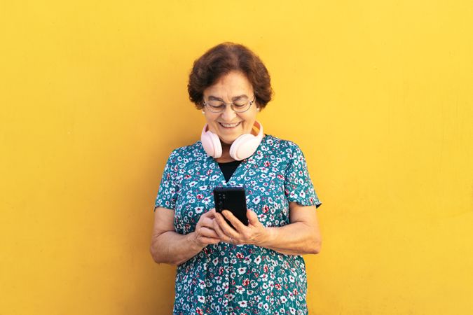 Smiling older woman using smartphone outdoors