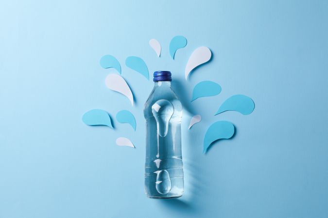 Looking down at full water bottle with decorative cut out water pieces