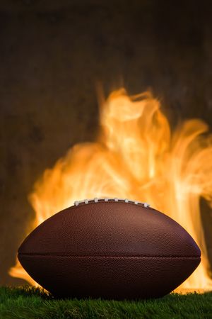 American football ball with fire at the background