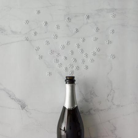 Champagne bottle with snow flakes on marble background