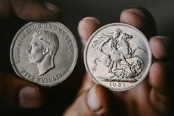 Hand holding five shillings