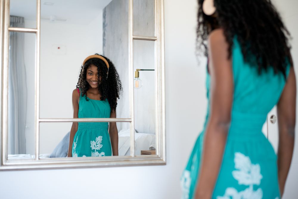 Black girl with headphones dancing in mirror