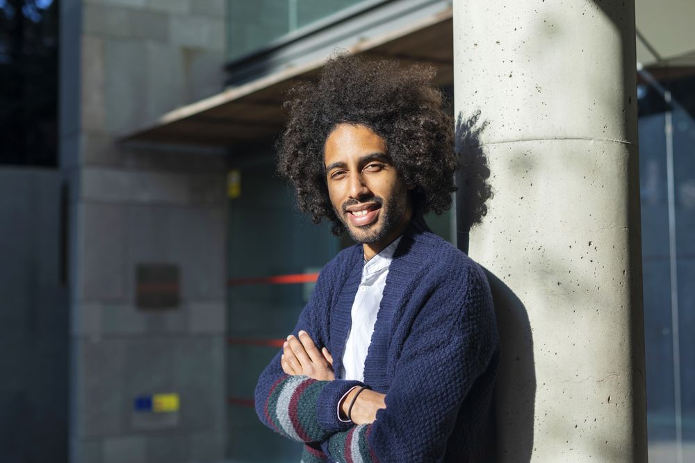 Smiling Black man standing with arms crossed on sunny day