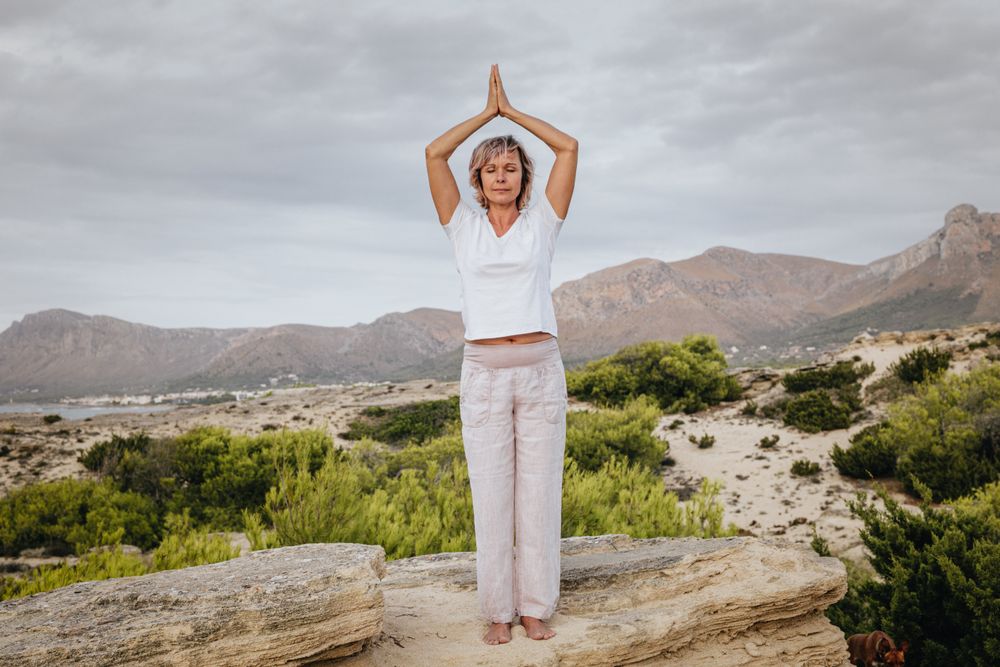 Barefoot woman meditating on stone
